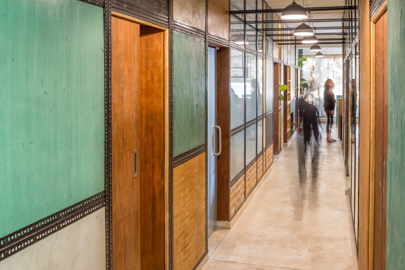 View of the main spline of the office contained by a collage of the natural plaster panels.