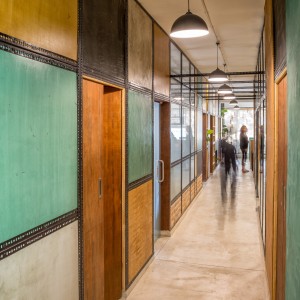 View of the main spline of the office contained by a collage of the natural plaster panels.