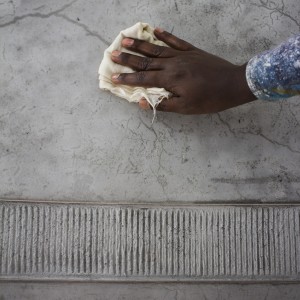 An artisan applies the first coat of a natural resinating oil on the lime plaster.